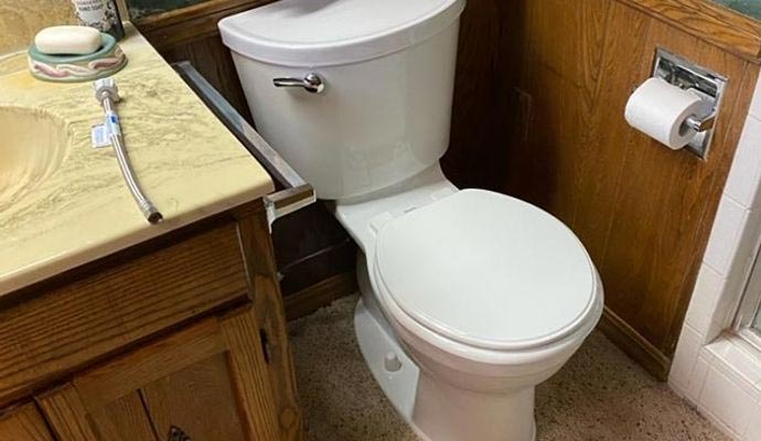 Bathroom toilet beside wooden vanity