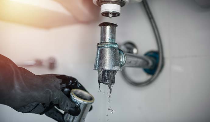 An expert plumber cleaning clogged sink drain trap