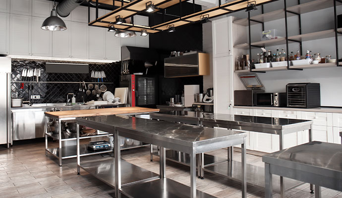 Commercial kitchen with stainless steel prep tables after grease cleaning