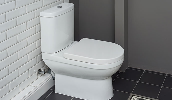 Modern white toilet in tiled bathroom