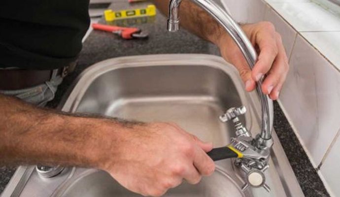 Person installing sink with equipment