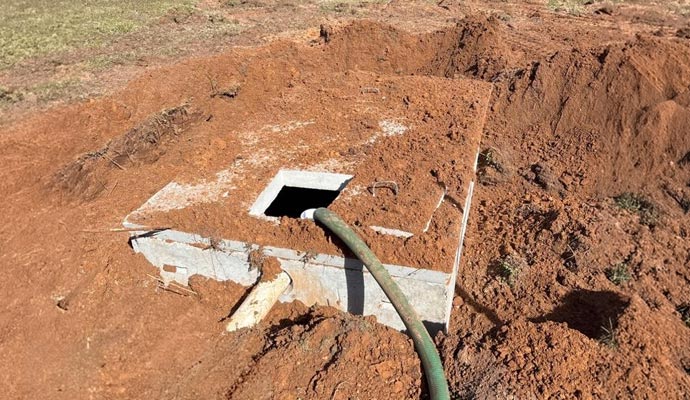 Partially buried septic tank structure with soil backfilling