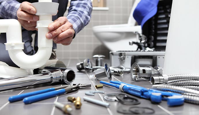 Plumber assembling sink trap with tools