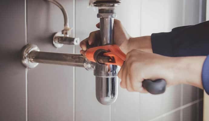 Professional plumber repairing a sink drainage system