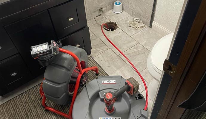 Bathroom drain cleaning using equipment