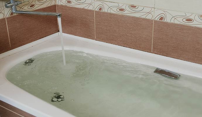 Bathtub with slow drain and standing water