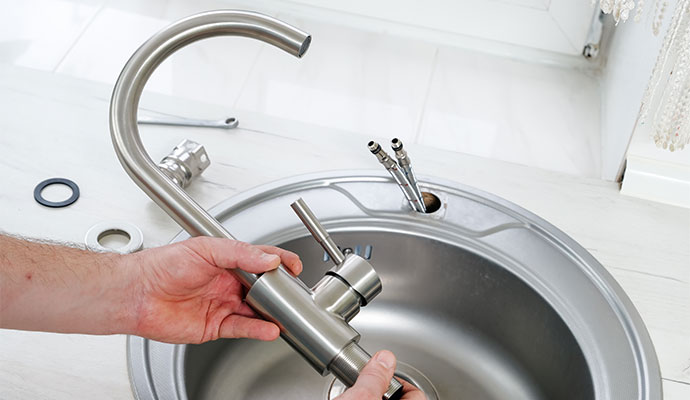 Expert installing kitchen faucet