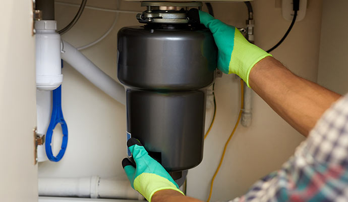 Person installing garbage disposal unit