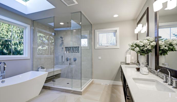 A modern master bathroom with a glass shower, freestanding tub, and double vanity. Luxury master bathroom with glass shower and freestanding tub