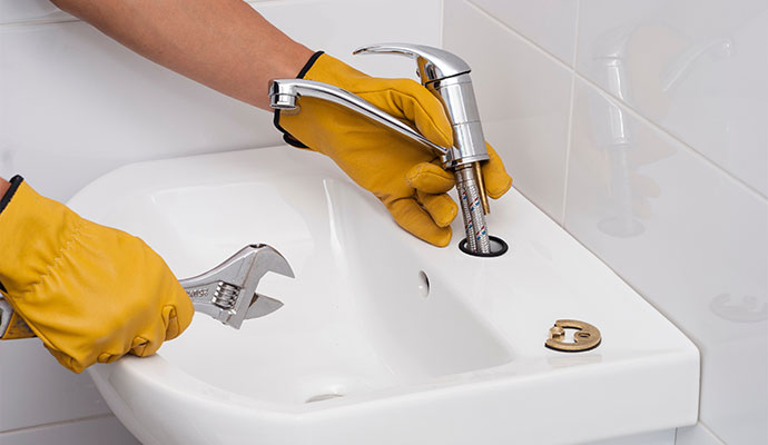 Technician repairing bathroom sink faucet