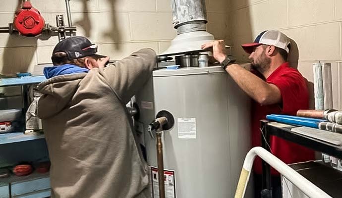 Two experts fixing plumbing issues of water heater