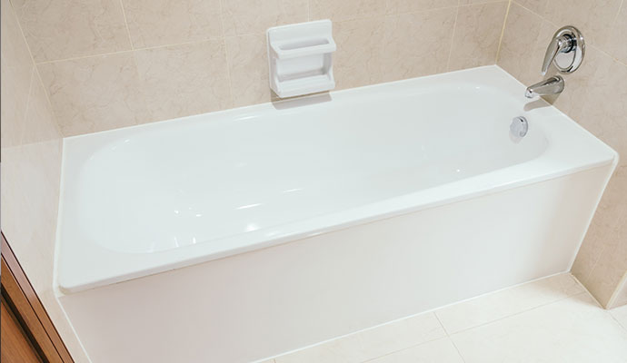 White alcove bathtub surrounded by tiled walls