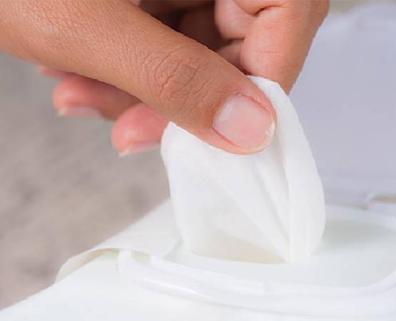 A person is pulling a wipe from a dispenser