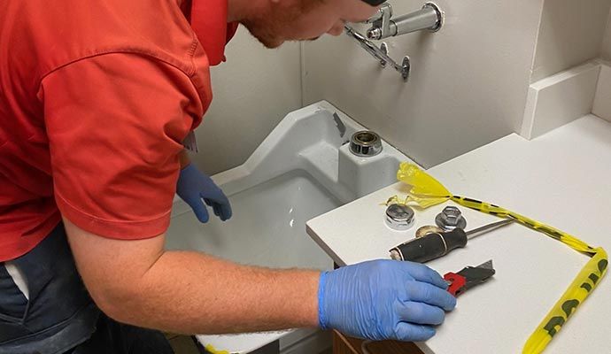 Person maintaining sink with equipment